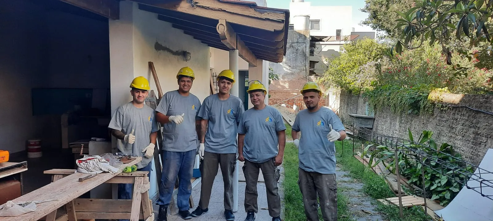 Equipo de obra de db Construcción & Arquitectura con cascos y remeras del estudio